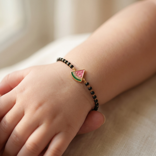 Child wearing black bead bracelet — 14k gold kids nazariya diamond bracelet with watermelon charm
