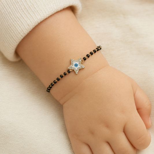 Child wearing star kids nazariya — 14K yellow gold bracelet with diamonds and protective black beads