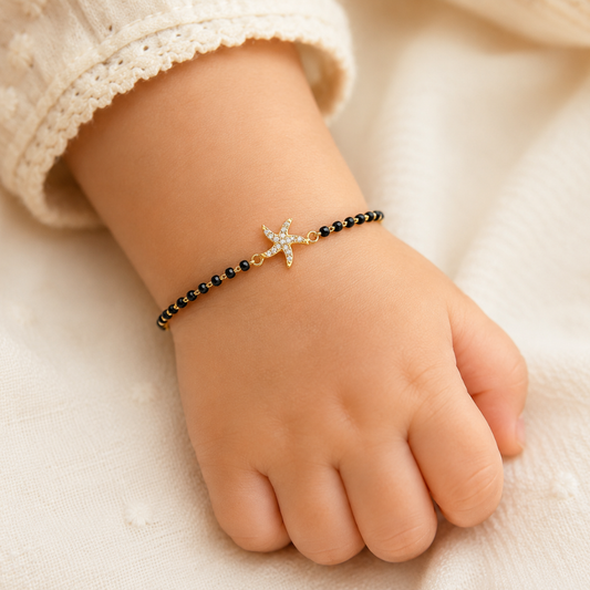 Baby wrist wearing starfish bracelet — 14k gold starfish kids nazariya with black beads