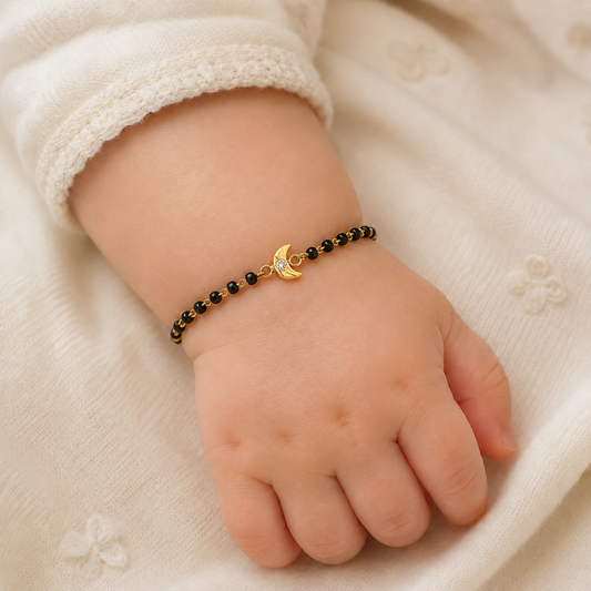 Baby wearing crescent moon nazariya — 14k gold diamond bracelet for baby with black beads
