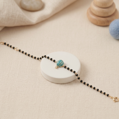 Child wearing hot air balloon nazariya — 14k gold diamond bracelet for baby with black beads
