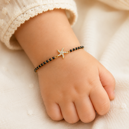 Baby wrist wearing starfish bracelet — 14k gold starfish kids nazariya with black beads