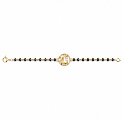 Front view of Ik Onkar charm — 14k gold kids nazariya with black beads
