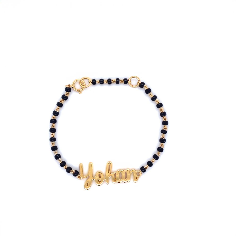 Personalised baby name bracelet on display — 14k gold kids nazariya with black beads