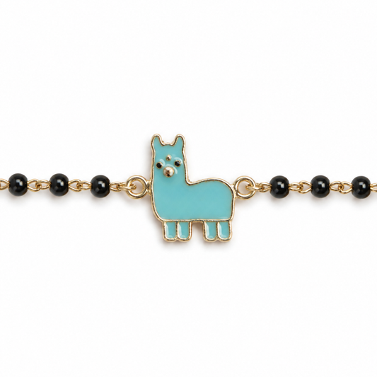 Turquoise llama charm close-up — 14k gold llama nazariya with protective black beads